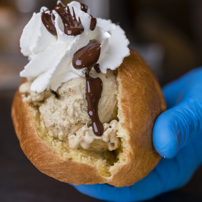 Artisan preparation of classic Italian maritozzo, sweet bun, with ice cream gelato and whipped cream.